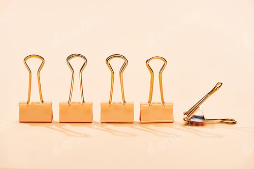 Preview: row of paper clips on beige background with copy space