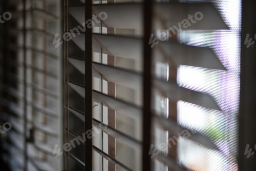 Preview: Timber venetian blinds on window casting shadows