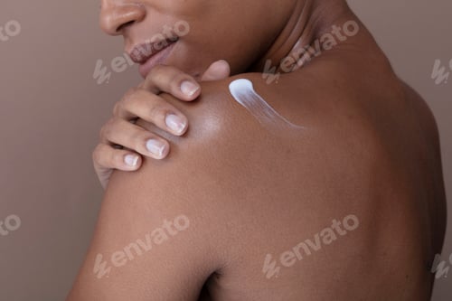 Preview: Close-up of woman applying moisturizer on shoulder