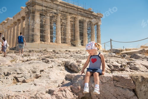 Preview: Cute little girl sitting near the Parthenon of Athenian Acropolis.