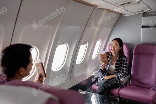 Preview: Asian couple sitting inside an airplane cabin