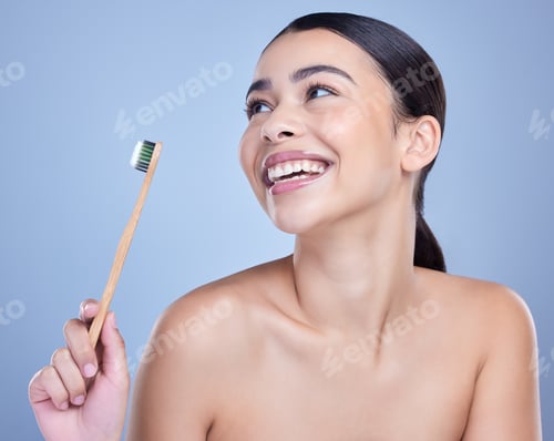 Preview: A smiling mixed race young woman with glowing skin posing against blue copyspace background while b