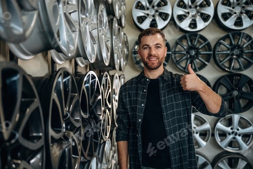 Preview: Thumb up, gesture. Man worker is maintenance station with tires, wheels
