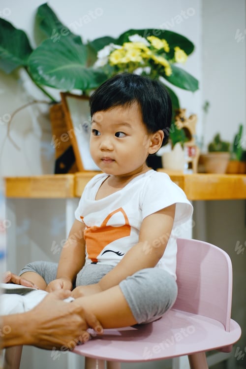 Preview: little boy sitting on wooden chair