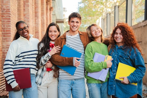 Preview: Group of high school friends, standing together at university campus smiling and expressing pure