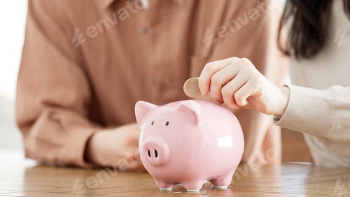 Preview: Couple putting money into a piggy bank