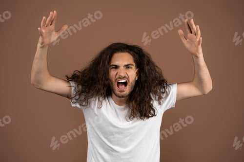 Preview: Young man with curly hair expresses intense emotions in isolated setting