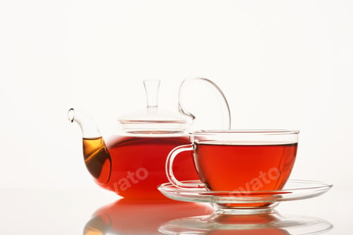 Preview: Glass cup of hot aromatic tea and teapot on white background