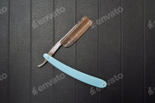 Preview: Rusty metal razor on black background