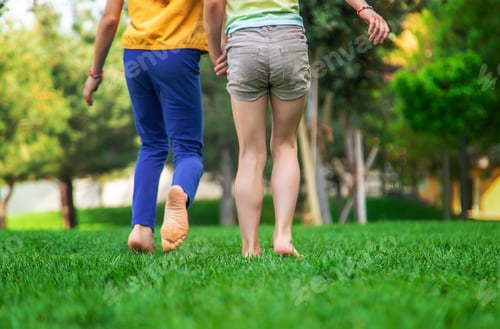 Preview: Children's feet go on the grass. Selective focus.