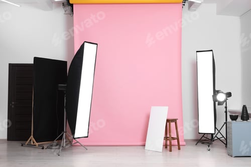Preview: Pink photo background, stool and professional lighting equipment in studio