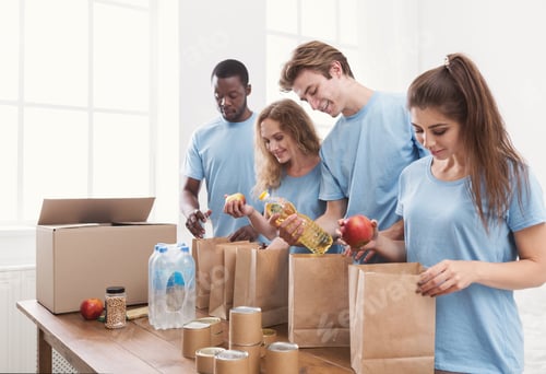 Preview: Volunteers packing food and drinks into paper bags