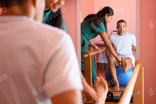 Preview: Physiotherapist assisting patient exercising in rehabilitation clinic