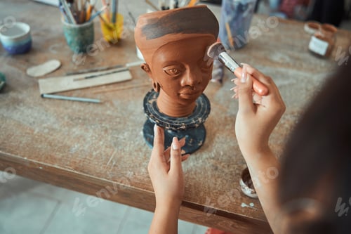 Preview: Female ceramist working with clay sculpture in workshop