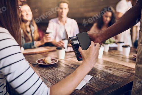 Preview: Just tap and go. Cropped shot of a woman paying with her phone at a cafe.