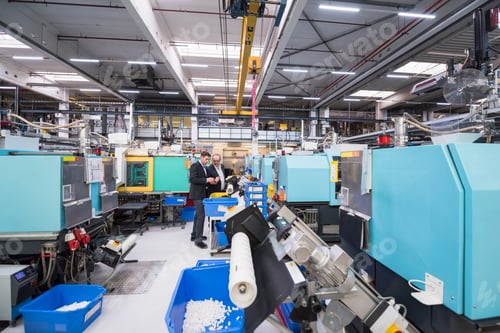 Preview: Two men talking in factory shop floor