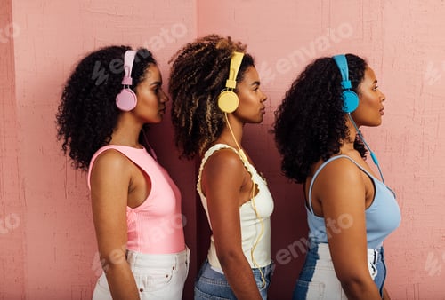 Preview: Side view of three women wearing headphones standing one after another against a pink wall