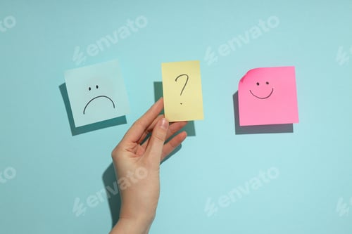 Preview: Hands holding paper with happy and angry face, bipolar disorder concept