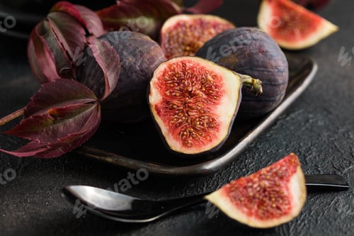 Preview: beautiful sweet purple fruit fig on black table background.