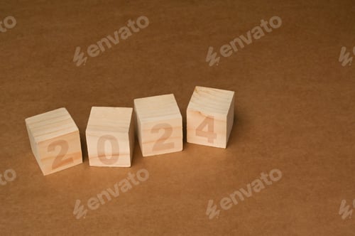 Preview: Wooden cube blocks with 2024 text on brown background. Start new year concept.