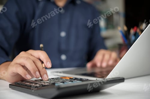 Preview: Businessman hand using calculator, laptop for financial analysis,