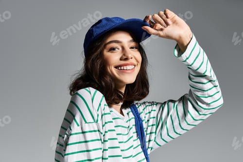 Preview: Young woman enjoys summer vibes in stylish striped attire with a playful hat on her head