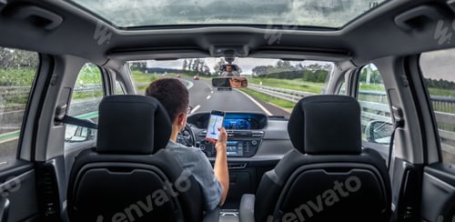 Preview: Driver holding phone for navigation. Modern travel vibe.