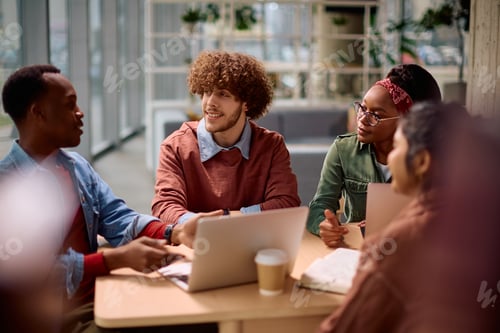Preview: Multiracial group of college friends cooperating while studying at campus.
