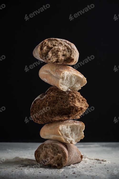 Preview: Pieces of different cracked fresh bread on a black background.