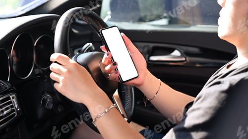 Preview: Man is driving car while holding and looking navigator on smart phone.