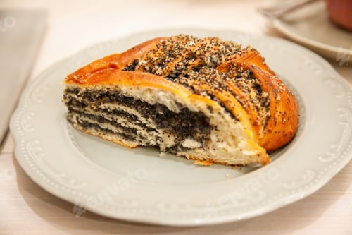 Preview: Delicious poppy seed pastry sits on a decorative plate in a cozy cafe
