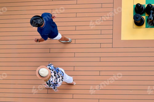 Preview: A senior couple is seen from above while walking along the promenade deck of a cruise ship and
