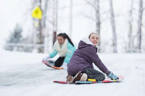 Preview: Two kids playing on a snow sled in winter