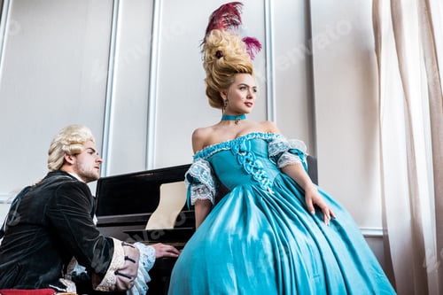 Preview: attractive victorian woman in blue dress standing near man in wig playing piano
