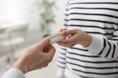 Preview: Gynecologist recommending contraceptive pills to woman in clinic, closeup