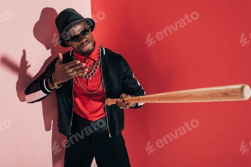 Preview: aggressive african american man holding bat and gesturing in studio