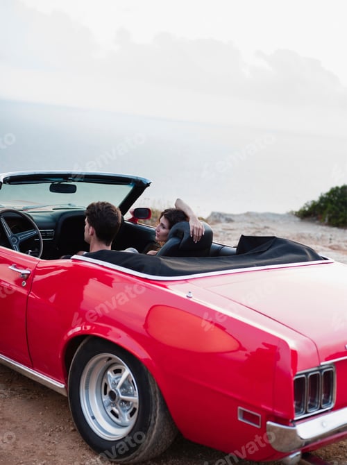 Preview: couple sitting in open-topped car