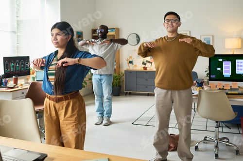 Preview: Diverse Adults Performing Group Stretching Exercise in Modern Office