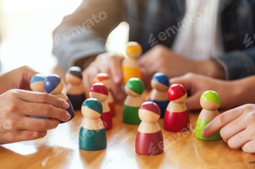 Preview: People choosing and picking up wooden figure from a group on the table