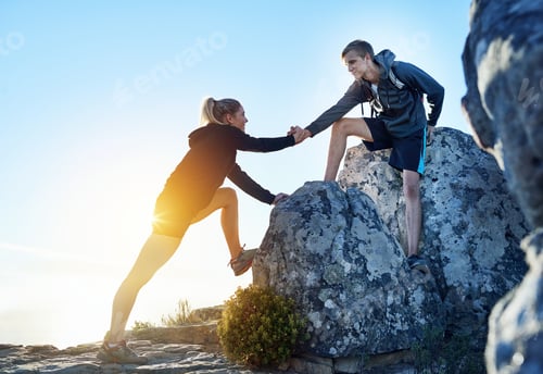 Preview: To the top, together. Full length shot of a young man helping his girlfriend while hiking.