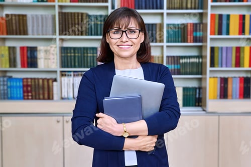 Preview: Portrait of female teacher with laptop in her hands in library