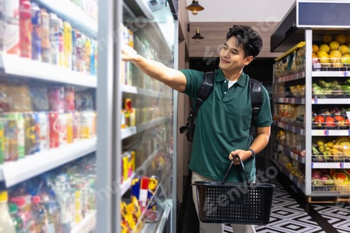 Preview: Happy Asian Young Man Shopping for Canned Beverages in Supermarket