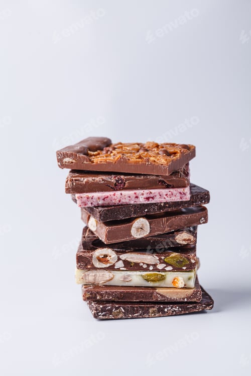 Preview: Stack of different types of chocolate on white background.