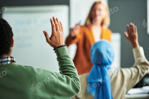 Preview: Raised hand of student working at seminar in front of speaker
