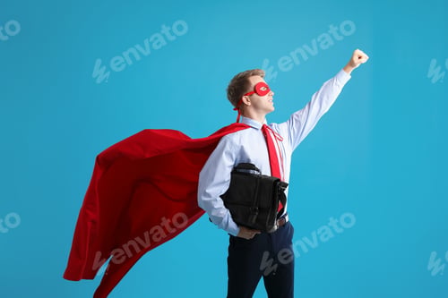 Preview: Businessman wearing superhero costume on light blue background