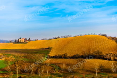 Preview: Scenic view of a rolling countryside landscape with houses in the background