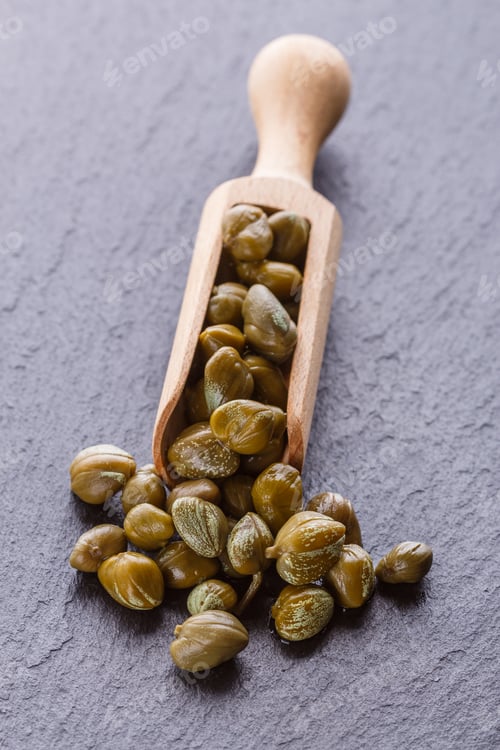 Preview: pickled capers on a dark stone background