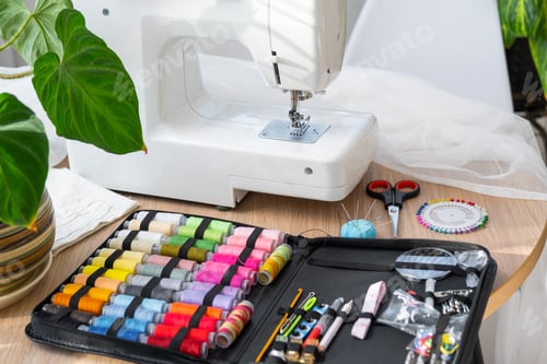 Preview: Sewing layout with multicolored spools of thread close-up, needles, electric sewing machine. Filling