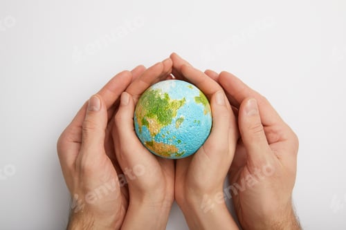 Preview: top view of woman and man holding planet model on grey background, earth day concept