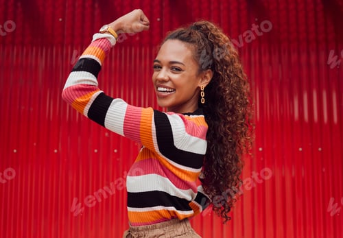 Preview: Beauty, fashion and strong with a black woman flexing her bicep outdoor on a red background with a